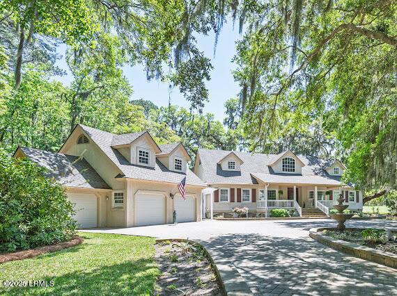9 Longwood Ct, Okatie, SC 29909 - cape cod house featuring concrete driveway, a porch, stucco siding, and an attached garage
