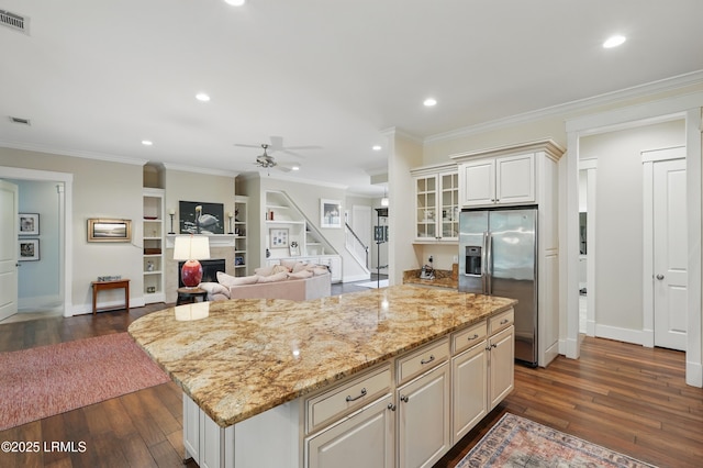 27 Normandy Ave, Bluffton, SC 29910 - kitchen with stainless steel fridge, dark wood-type flooring, a kitchen island, ornamental molding, and light stone counters