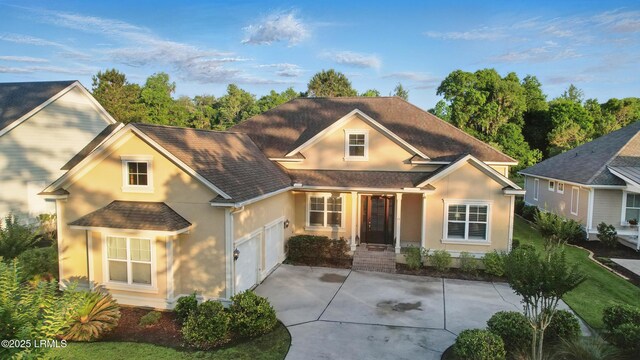 27 Normandy Ave, Bluffton, SC 29910 - traditional-style home with stucco siding, a garage, driveway, and roof with shingles