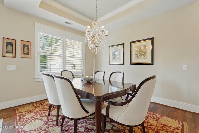27 Normandy Ave, Bluffton, SC 29910 - dining room featuring ornamental molding, a chandelier, baseboards, wood finished floors, and a tray ceiling