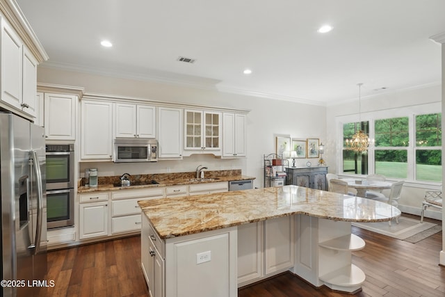 27 Normandy Ave, Bluffton, SC 29910 - kitchen with appliances with stainless steel finishes, a kitchen island, a chandelier, crown molding, and light stone countertops