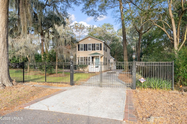 view of front of property featuring a fenced front yard, driveway, and a gate