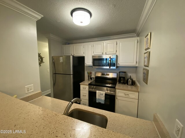 171 Beach Club Villa Dr Unit 171, Fripp Island, SC 29920 - kitchen featuring stainless steel appliances, ornamental molding, white cabinetry, light stone countertops, and a textured ceiling
