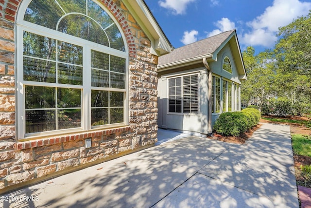 1980 Abbey Glen Way Unit 1980, Hardeeville, SC 29927 - exterior space with stone siding, a patio, and roof with shingles