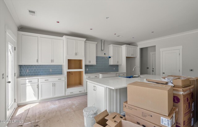 1 Alumni Rd, Beaufort, SC 29907 - kitchen with visible vents, an island with sink, white cabinetry, tasteful backsplash, and a sink