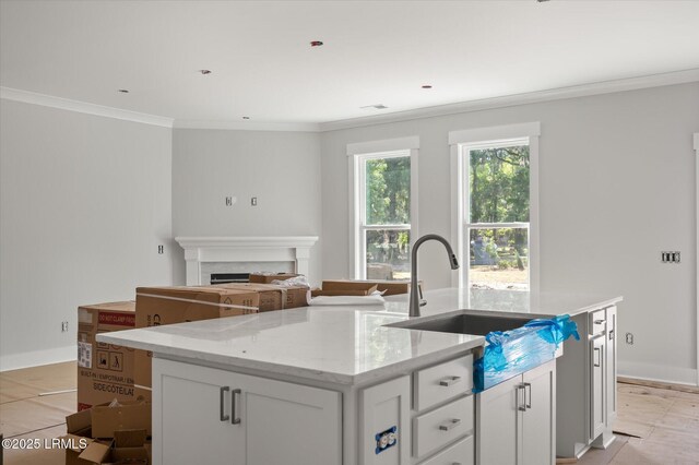 1 Alumni Rd, Beaufort, SC 29907 - kitchen featuring a kitchen island with sink, crown molding, a fireplace, a sink, and white cabinets