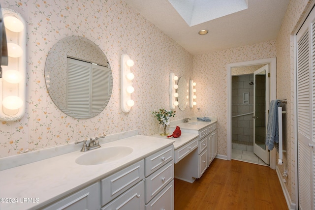 bathroom featuring vanity, hardwood / wood-style floors, and a skylight