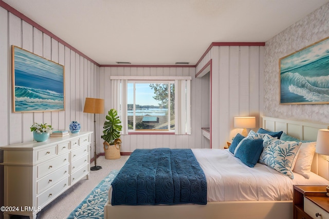 carpeted bedroom with crown molding and a water view