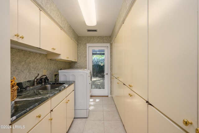 clothes washing area with washer / clothes dryer, cabinets, sink, and light tile patterned flooring