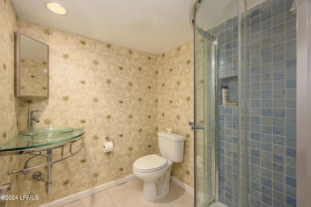 bathroom with tile patterned flooring, a shower with door, sink, and toilet