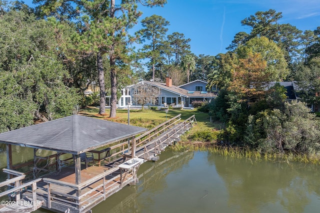 dock area with a water view and a yard