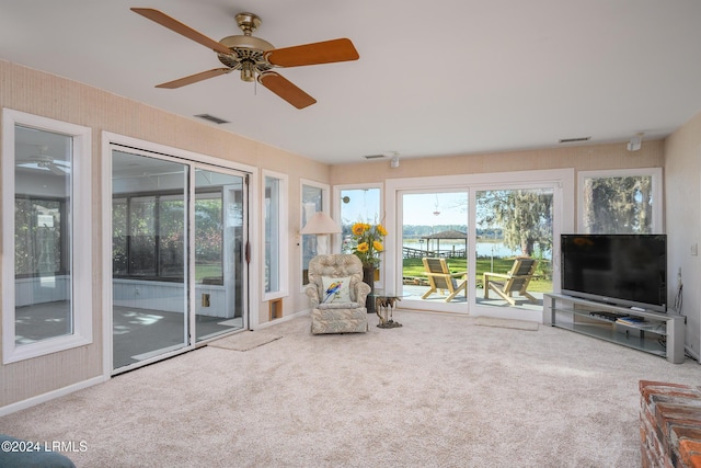 interior space featuring ceiling fan, carpet flooring, and a wealth of natural light