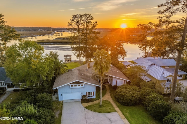 aerial view at dusk featuring a water view