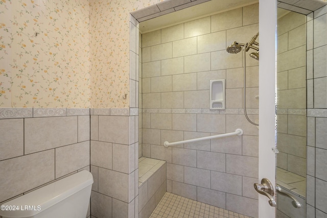 bathroom featuring tiled shower and toilet