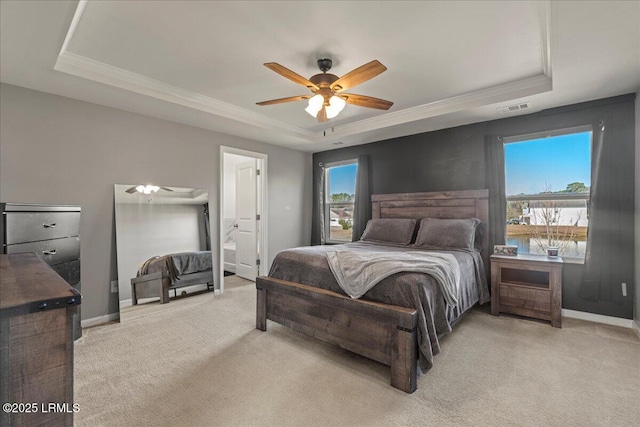 carpeted bedroom featuring ceiling fan, ornamental molding, and a tray ceiling