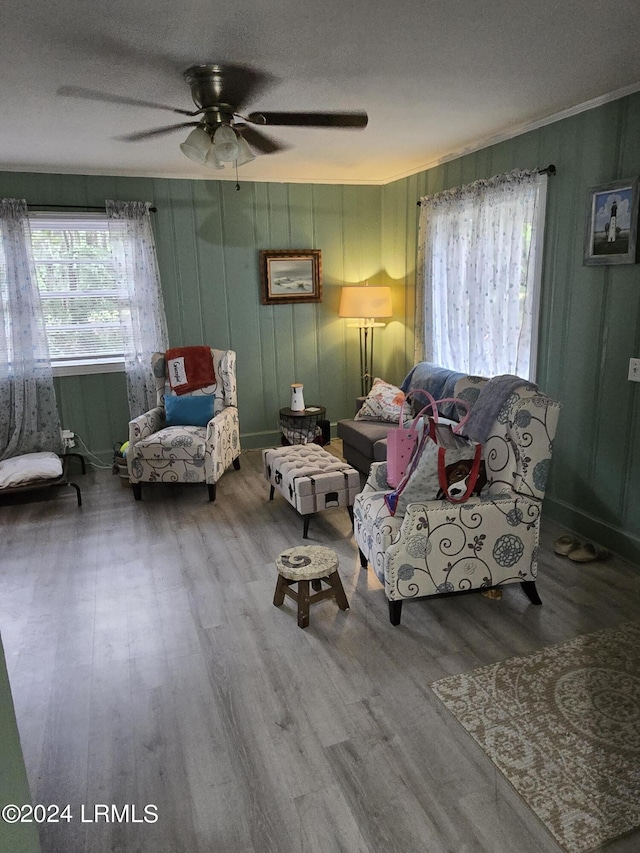 living room with hardwood / wood-style flooring, ceiling fan, and a textured ceiling