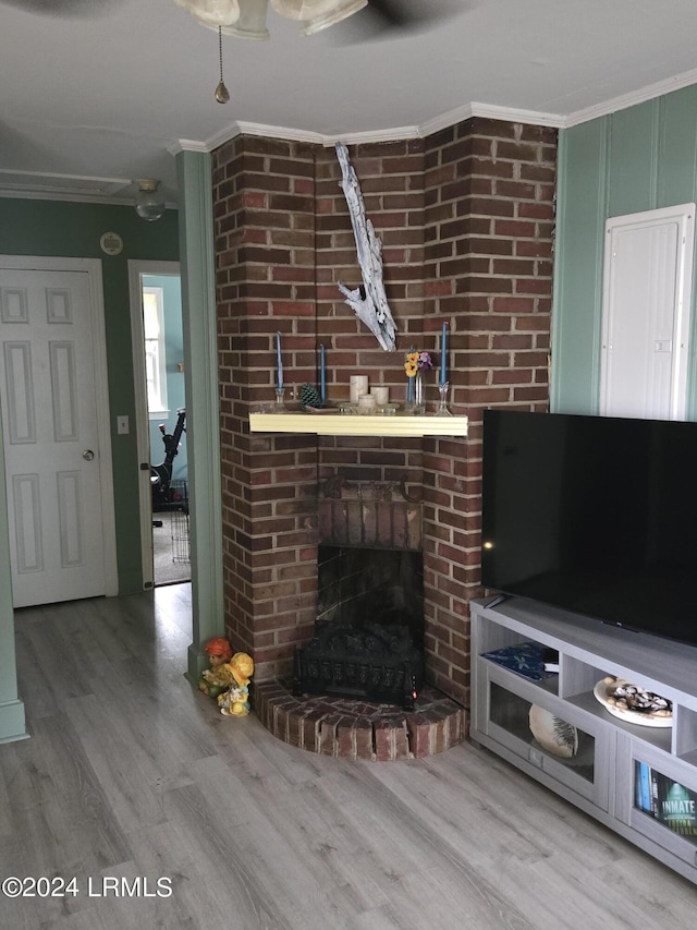 unfurnished living room featuring hardwood / wood-style flooring, ornamental molding, and a fireplace