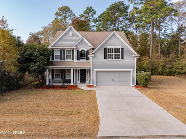 view of property featuring a porch, a garage, and a front lawn