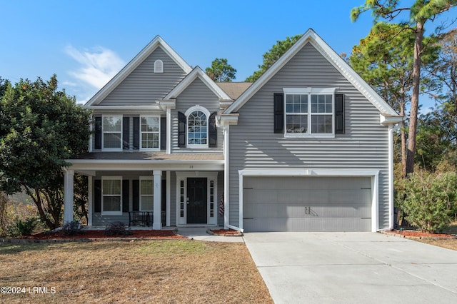 view of front property with a garage, a front yard, and a porch