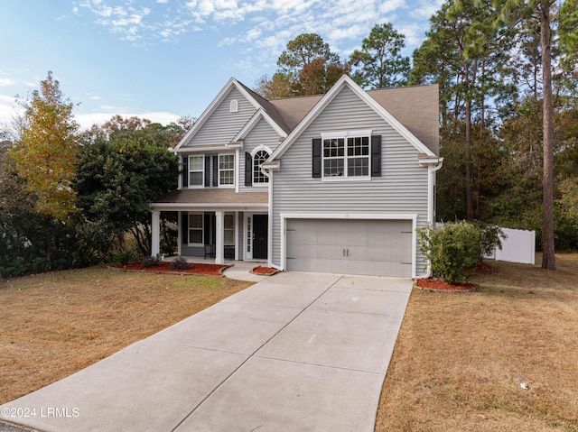 view of property with a garage, a front yard, and covered porch