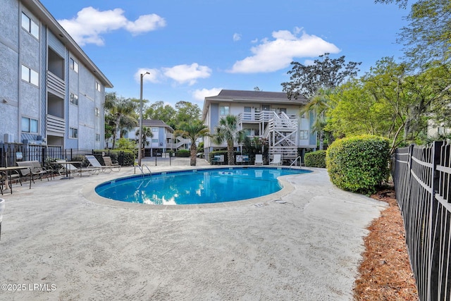 pool with fence and a patio area