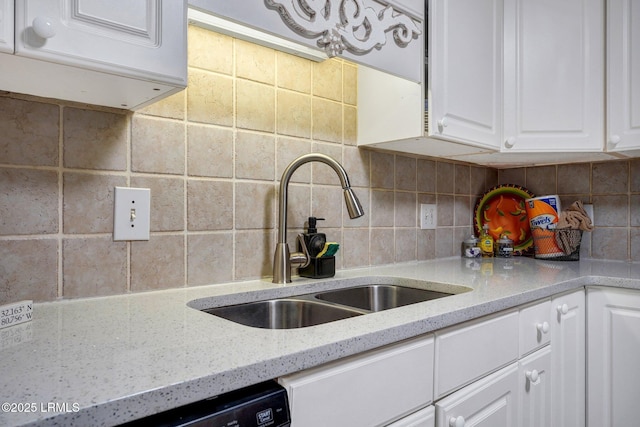 kitchen with a sink, backsplash, light stone counters, white cabinetry, and dishwasher