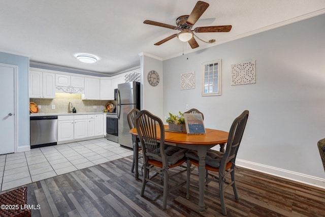 dining room with ceiling fan, baseboards, ornamental molding, and light wood-style floors