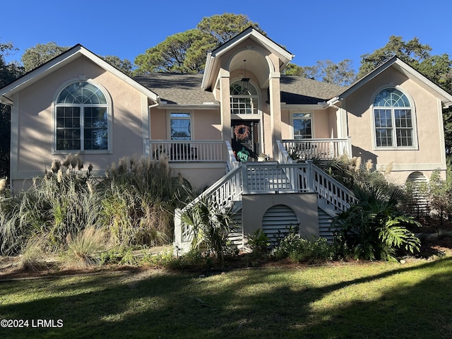 view of front of home with a porch and a front lawn