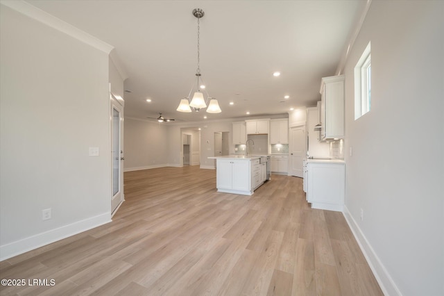 29 Fairfield Rd, Beaufort, SC 29907 - kitchen with a kitchen island, light hardwood / wood-style flooring, white cabinets, and decorative light fixtures