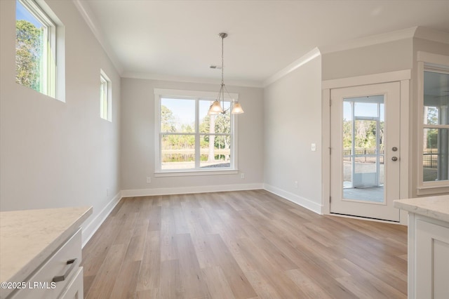 29 Fairfield Rd, Beaufort, SC 29907 - unfurnished dining area with a notable chandelier, crown molding, a healthy amount of sunlight, and light wood-type flooring