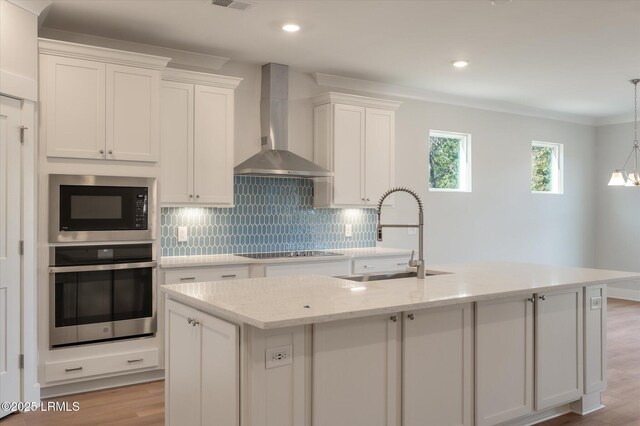 29 Fairfield Rd, Beaufort, SC 29907 - kitchen featuring a kitchen island with sink, wall chimney range hood, sink, and stainless steel oven