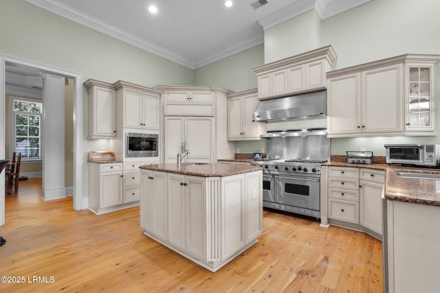 44 Richland Dr, Bluffton, SC 29910 - kitchen featuring crown molding, dark stone counters, under cabinet range hood, a sink, and stainless steel appliances