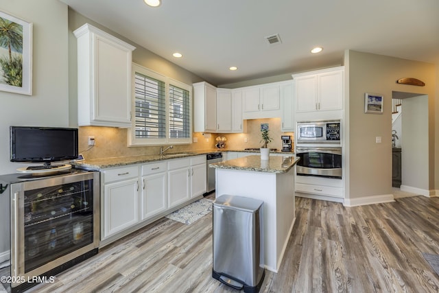 300 Persimmon Cir, Hardeeville, SC 29927 - kitchen featuring beverage cooler, stainless steel appliances, light wood-style flooring, white cabinets, and recessed lighting