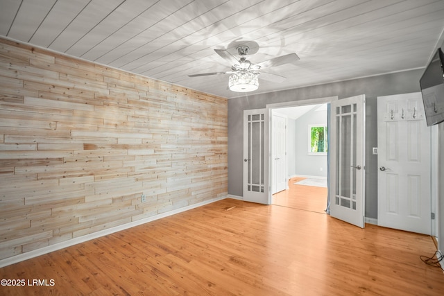 106 Sand Piper Run, Fripp Island, SC 29920 - empty room with wood walls, french doors, a ceiling fan, and light wood finished floors