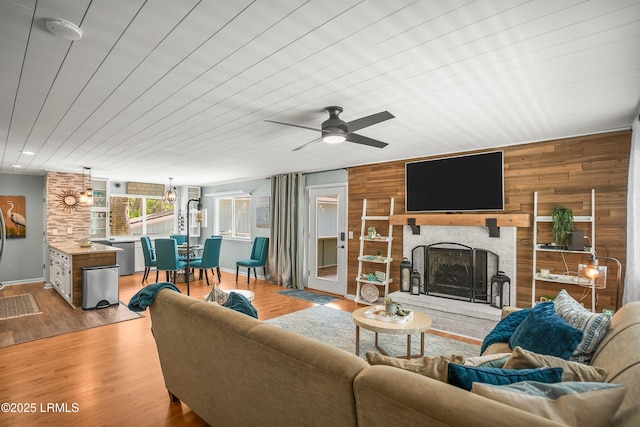 106 Sand Piper Run, Fripp Island, SC 29920 - living area with wood walls, a fireplace with raised hearth, ceiling fan, wood finished floors, and wooden ceiling