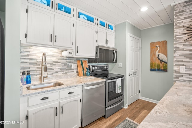 106 Sand Piper Run, Fripp Island, SC 29920 - kitchen featuring appliances with stainless steel finishes, white cabinetry, backsplash, light wood-style floors, and light stone countertops