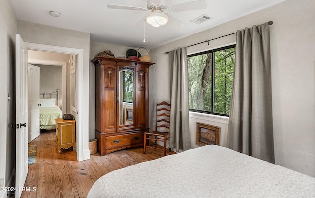 bedroom featuring multiple windows, hardwood / wood-style flooring, and ceiling fan