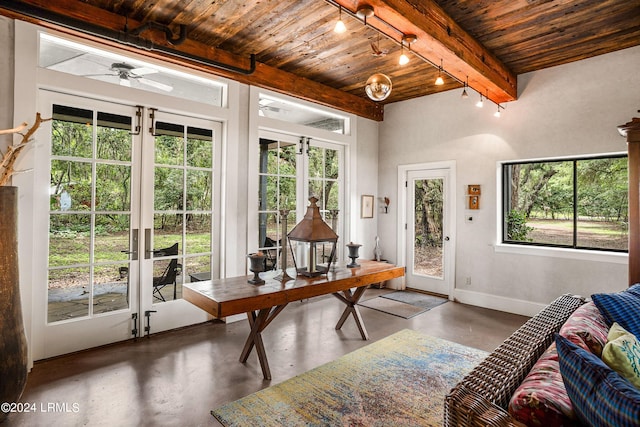 sunroom featuring wood ceiling, beam ceiling, track lighting, and a healthy amount of sunlight