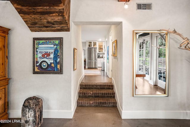 stairway with concrete flooring and lofted ceiling with beams