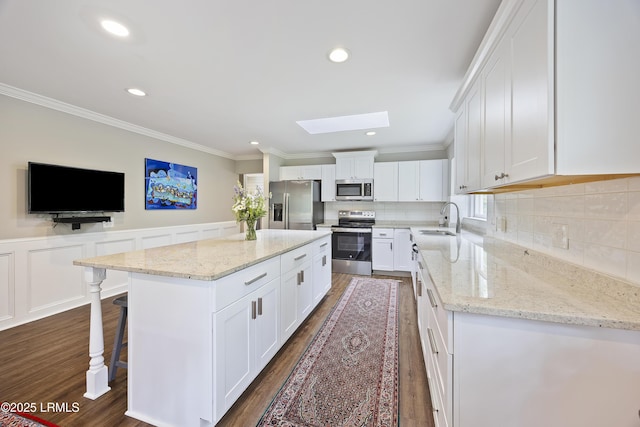 51 White Oaks Cir, Bluffton, SC 29910 - kitchen featuring appliances with stainless steel finishes, a sink, a skylight, ornamental molding, and dark wood finished floors