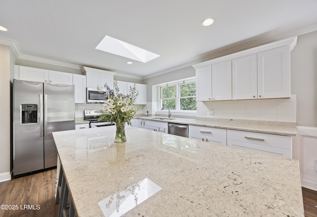 51 White Oaks Cir, Bluffton, SC 29910 - kitchen featuring stainless steel appliances, a skylight, a sink, crown molding, and white cabinetry