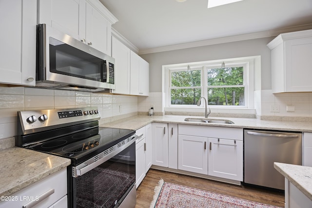 51 White Oaks Cir, Bluffton, SC 29910 - kitchen featuring stainless steel appliances, a sink, crown molding, wood finished floors, and white cabinets