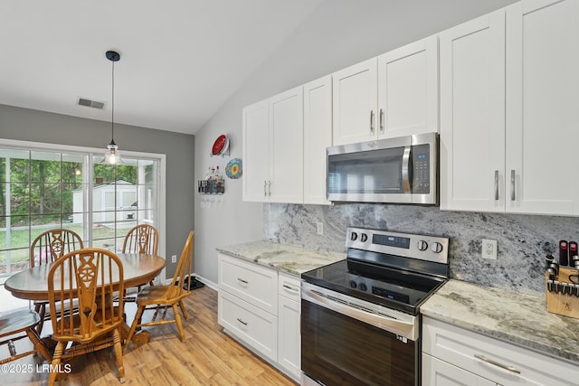 29 Wiregrass Way, Bluffton, SC 29910 - kitchen with stainless steel appliances, vaulted ceiling, tasteful backsplash, light wood-type flooring, and white cabinets