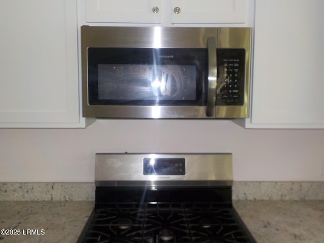 127 Teal Bluff Blvd, Seabrook, SC 29940 - detailed view of stainless steel appliances, white cabinetry, and light stone counters