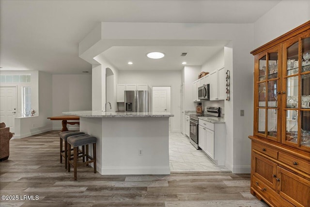 61 Hampton Cir, Bluffton, SC 29909 - kitchen with appliances with stainless steel finishes, a breakfast bar area, baseboards, and recessed lighting