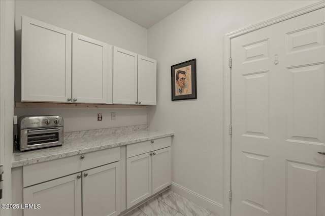 61 Hampton Cir, Bluffton, SC 29909 - kitchen with light marble finish flooring, baseboards, light stone countertops, and white cabinetry
