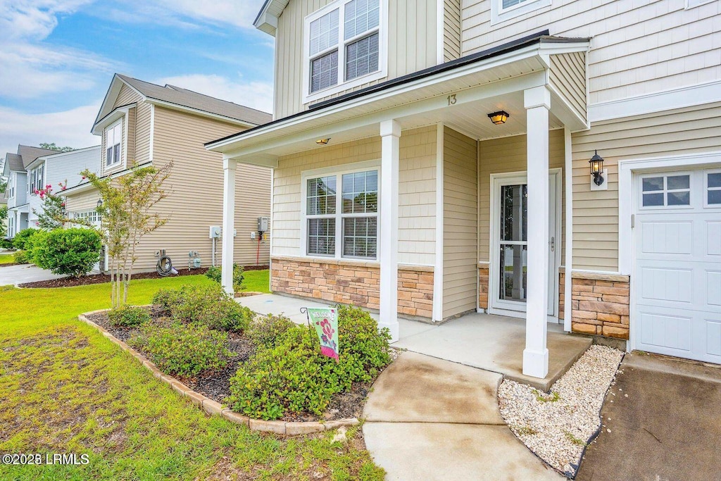 13 Combahee Way, Beaufort, SC 29906 - doorway to property featuring stone siding, board and batten siding, and covered porch