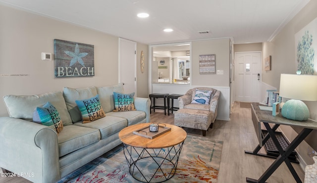 living room featuring hardwood / wood-style flooring and crown molding