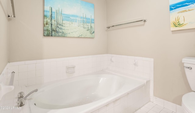 bathroom with tiled tub, tile patterned flooring, and toilet