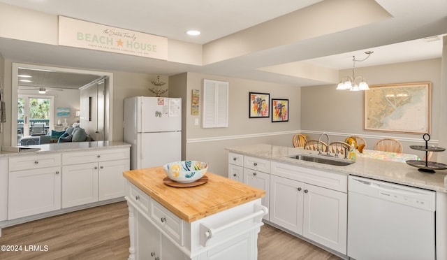 kitchen featuring a kitchen island, sink, white cabinets, light stone counters, and white appliances